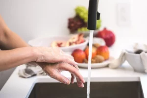 Picture of a person washing their hands under a running faucet due to a working well water pump