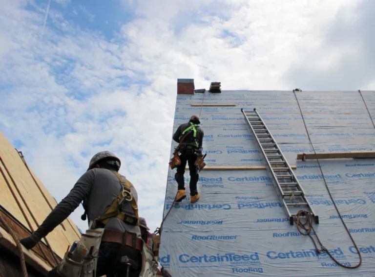 Two roofers on steep roof slopes church roof replacement 1 1024x754 1 768x566